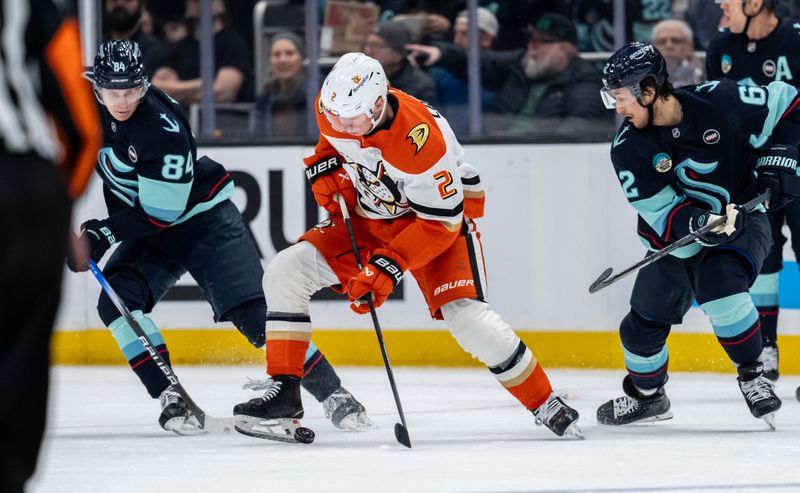 Jan 28, 2025; Seattle, Washington, USA;  Anaheim Ducks defenseman Jackson LaCombe (2) battles Seattle Kraken forward Kaapo Kakko (84) and defenseman Brandon Montour (62) for the puck during the first period at Climate Pledge Arena. Mandatory Credit: Stephen Brashear-Imagn Images