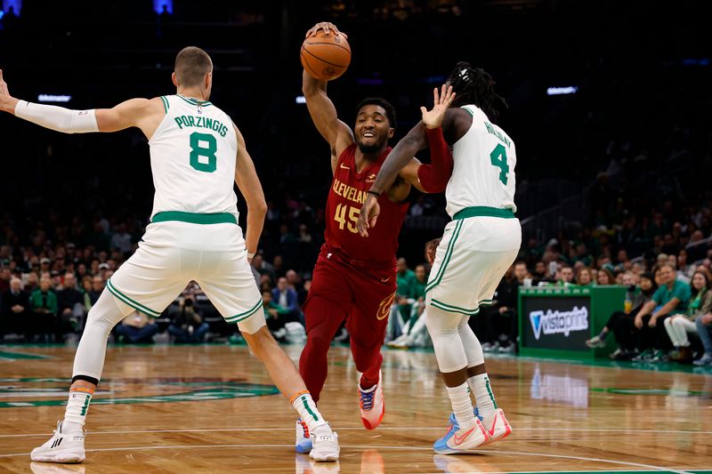 BOSTON, MA - DECEMBER 14: Donovan Mitchell #45 of the Cleveland Cavaliers tries to get between Kristaps Porzingis #8 and Jrue Holiday #4 of the Boston Celtics during the first quarter at TD Garden on December 14, 2023 in Boston, Massachusetts. NOTE TO USER: User expressly acknowledges and agrees that, by downloading and/or using this Photograph, user is consenting to the terms and conditions of the Getty Images License Agreement. (Photo By Winslow Townson/Getty Images)