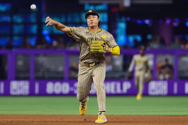 Aug 11, 2024; Miami, Florida, USA; San Diego Padres shortstop Ha-Seong Kim (7) turns a double play against the Miami Marlins during the fifth inning at loanDepot Park. Mandatory Credit: Sam Navarro-USA TODAY Sports