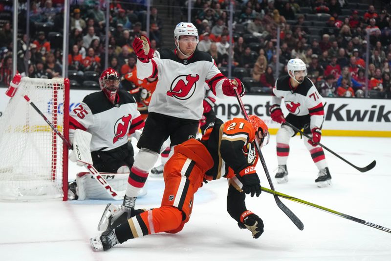 Dec 31, 2024; Anaheim, California, USA; Anaheim Ducks center Isac Lundestrom (21) collides with New Jersey Devils center Curtis Lazar (42) in the third period at Honda Center. Mandatory Credit: Kirby Lee-Imagn Images