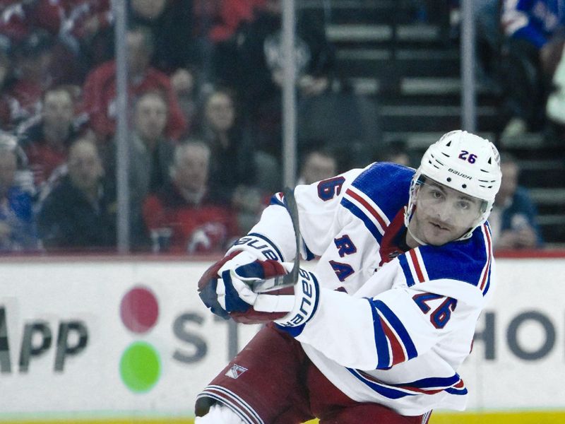 Feb 22, 2024; Newark, New Jersey, USA; New York Rangers left wing Jimmy Vesey (26) passes the puck against the New Jersey Devils during the first period at Prudential Center. Mandatory Credit: John Jones-USA TODAY Sports