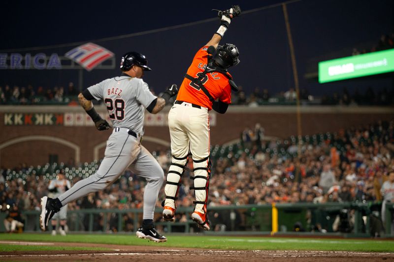Aug 9, 2024; San Francisco, California, USA; Detroit Tigers shortstop Javier Báez (28) scores as San Francisco Giants catcher Curt Casali (2) leaps for an errant relay during the fifth inning at Oracle Park. Mandatory Credit: D. Ross Cameron-USA TODAY Sports