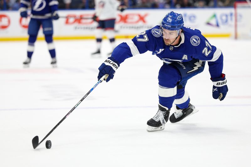 Mar 4, 2025; Tampa, Florida, USA; Tampa Bay Lightning defenseman Ryan McDonagh (27) controls the puck against the Columbus Blue Jackets in the first period at Amalie Arena. Mandatory Credit: Nathan Ray Seebeck-Imagn Images