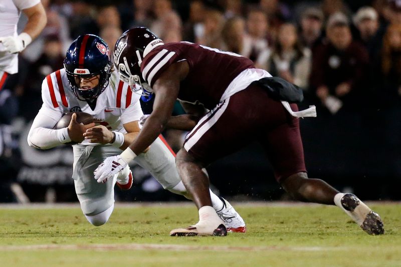 Nov 23, 2023; Starkville, Mississippi, USA; Mississippi Rebels quarterback Jaxson Dart (2) runs the ball as Mississippi State Bulldogs linebacker DeShawn Page (0) make the tackle during the second half at Davis Wade Stadium at Scott Field. Mandatory Credit: Petre Thomas-USA TODAY Sports