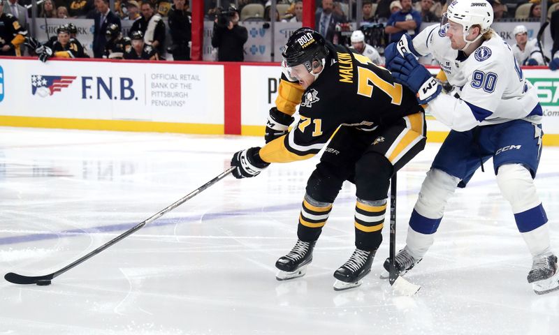 Nov 19, 2024; Pittsburgh, Pennsylvania, USA;  Pittsburgh Penguins center Evgeni Malkin (71) skates with the puck as Tampa Bay Lightning defenseman J.J. Moser (90) chases during the third period at PPG Paints Arena. Mandatory Credit: Charles LeClaire-Imagn Images