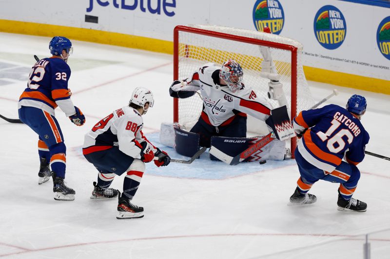 Apr 6, 2025; Elmont, New York, USA;  Washington Capitals goaltender Charlie Lingren (79) blocks a shot by New York Islanders forward Marc Gatcome (16) during the third period at UBS Arena. Mandatory Credit: Geoff Burke-Imagn Images