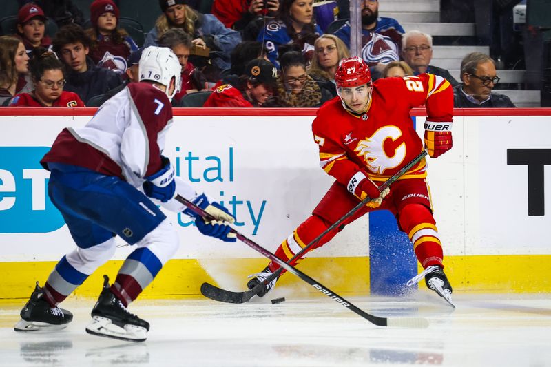 Mar 14, 2025; Calgary, Alberta, CAN; Calgary Flames right wing Matt Coronato (27) controls the puck against Colorado Avalanche defenseman Devon Toews (7) during the second period at Scotiabank Saddledome. Mandatory Credit: Sergei Belski-Imagn Images