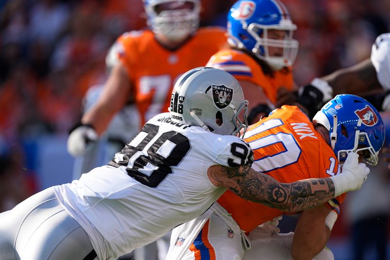 Las Vegas Raiders defensive end Maxx Crosby (98) sacks Denver Broncos quarterback Bo Nix (10) during the second half of an NFL football game, Sunday, Oct. 6, 2024, in Denver. (AP Photo/David Zalubowski)