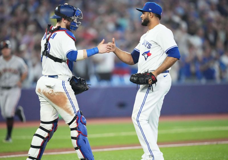 Jun 28, 2023; Toronto, Ontario, CAN; Toronto Blue Jays catcher Danny Jansen (9) celebrates the win with relief pitcher Yimi Garcia (93) against the San Francisco Giants at the end of the ninth inning at Rogers Centre. Mandatory Credit: Nick Turchiaro-USA TODAY Sports