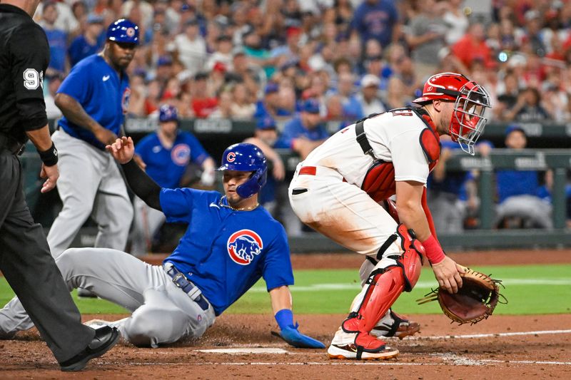 Jul 28, 2023; St. Louis, Missouri, USA;  Chicago Cubs right fielder Seiya Suzuki (27) slides safely past St. Louis Cardinals catcher Andrew Knizner (7) to score during the sixth inning at Busch Stadium. Mandatory Credit: Jeff Curry-USA TODAY Sports