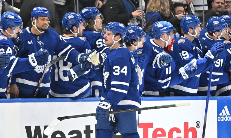 Dec 2, 2023; Toronto, Ontario, CAN; Toronto Maple Leafs forward Auston Matthews (34) celebrates with team mates at the bench after scoring against the Boston Bruins in the second period at Scotiabank Arena. Mandatory Credit: Dan Hamilton-USA TODAY Sports