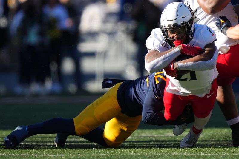 Nov 18, 2023; Morgantown, West Virginia, USA; Cincinnati Bearcats running back Corey Kiner (21) carries the ball against the West Virginia Mountaineers in the first quarter at Milan Puskar Stadium.  Mandatory Credit: Kareem Elgazzar-USA TODAY Sports