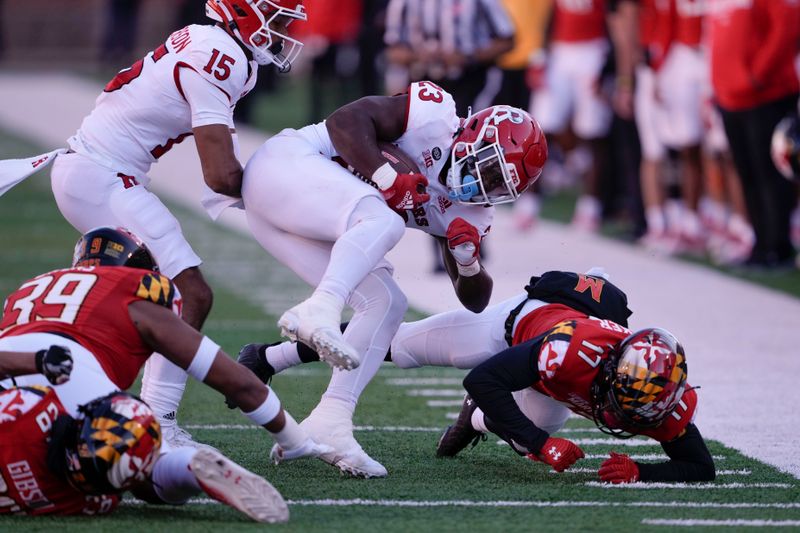 Nov 26, 2022; College Park, Maryland, USA; Rutgers Scarlet Knights running back Kyle Monangai (23) is tackled by multiple Maryland Terrapins during the fourth quarter at SECU Stadium. Mandatory Credit: Brent Skeen-USA TODAY Sports