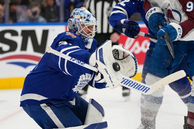 Jan 13, 2024; Toronto, Ontario, CAN; Toronto Maple Leafs goaltender Martin Jones (31) makes a save as Colorado Avalanche forward Mikko Rantanen (96) tries to knock in the rebound during the second period at Scotiabank Arena. Mandatory Credit: John E. Sokolowski-USA TODAY Sports