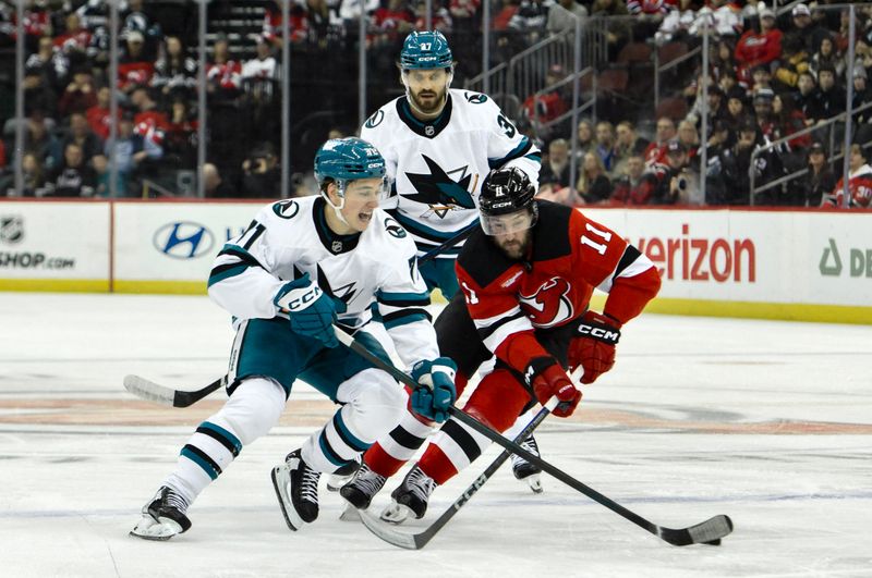 Nov 10, 2024; Newark, New Jersey, USA; San Jose Sharks center Macklin Celebrini (71) skates with the puck against New Jersey Devils right wing Stefan Noesen (11) during the first period at Prudential Center. Mandatory Credit: John Jones-Imagn Images