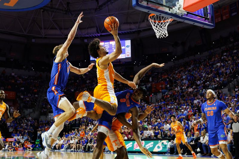 Jan 10, 2026; Gainesville, Florida, USA; Tennessee Volunteers guard Ja'kobi Gillespie (0) attempts a shot over Florida Gators forward Thomas Haugh (10) and Florida Gators center Rueben Chinyelu (9) during the first half at Exactech Arena at the Stephen C. O'Connell Center. Mandatory Credit: Matt Pendleton-Imagn Images