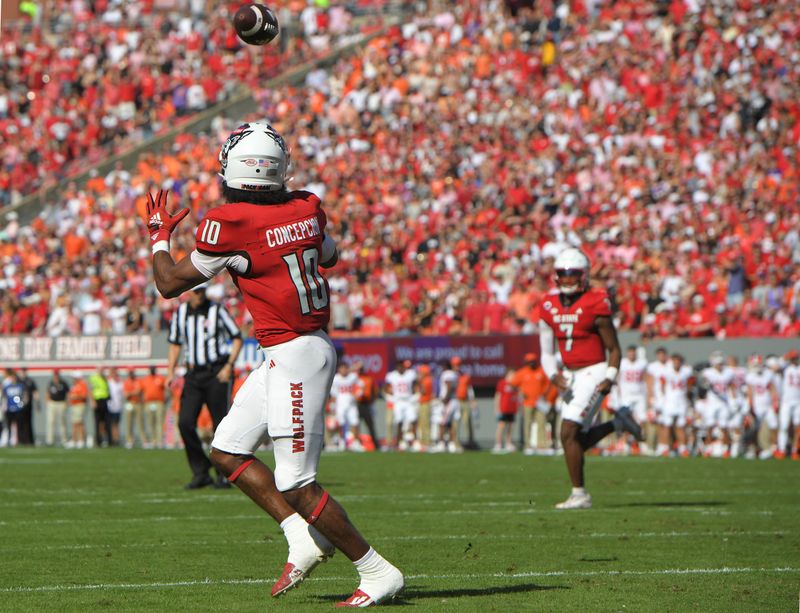 Oct 28, 2023; Raleigh, North Carolina, USA; North Carolina State Wolfpack receiver Kevin KC Concepcion (10) scores a touchdown against the Clemson Tigers during the first quarter at Carter-Finley Stadium. Mandatory Credit: Ken Ruinard-USA TODAY Sports