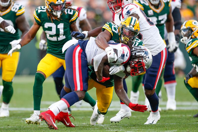 Green Bay Packers safety Rudy Ford (20) tackles New England Patriots running back Rhamondre Stevenson (38) during the second half of an NFL football game, Sunday, Oct. 2, 2022, in Green Bay, Wis. (AP Photo/Kamil Krzaczynski)