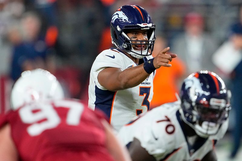 Denver Broncos quarterback Russell Wilson, middle, signals at the line of scrimmage during the first half of an NFL preseason football game against the Arizona Cardinals in Glendale, Ariz., Friday, Aug. 11, 2023. (AP Photo/Matt York)