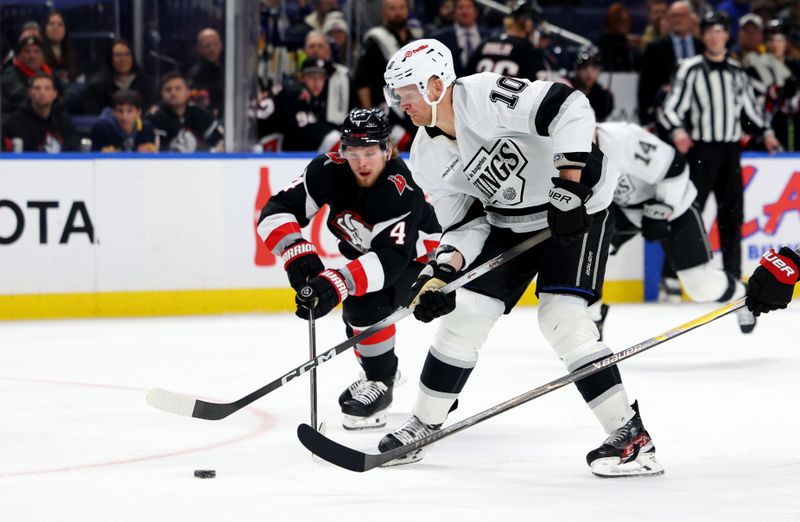 Jan 29, 2026; Buffalo, New York, USA;  Los Angeles Kings right wing Corey Perry (10) skates with the puck as Buffalo Sabres defenseman Bowen Byram (4) tries to knock the puck away during the third period at KeyBank Center. Mandatory Credit: Timothy T. Ludwig-Imagn Images