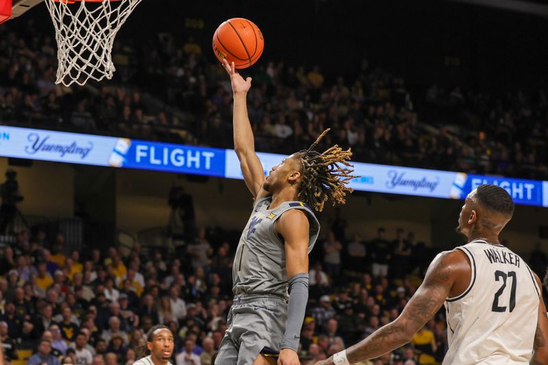 Jan 23, 2024; Orlando, Florida, USA; West Virginia Mountaineers guard Noah Farrakhan (1) goes to the basket in front of UCF Knights forward C.J. Walker (21) during the first half at Addition Financial Arena. Mandatory Credit: Mike Watters-USA TODAY Sports