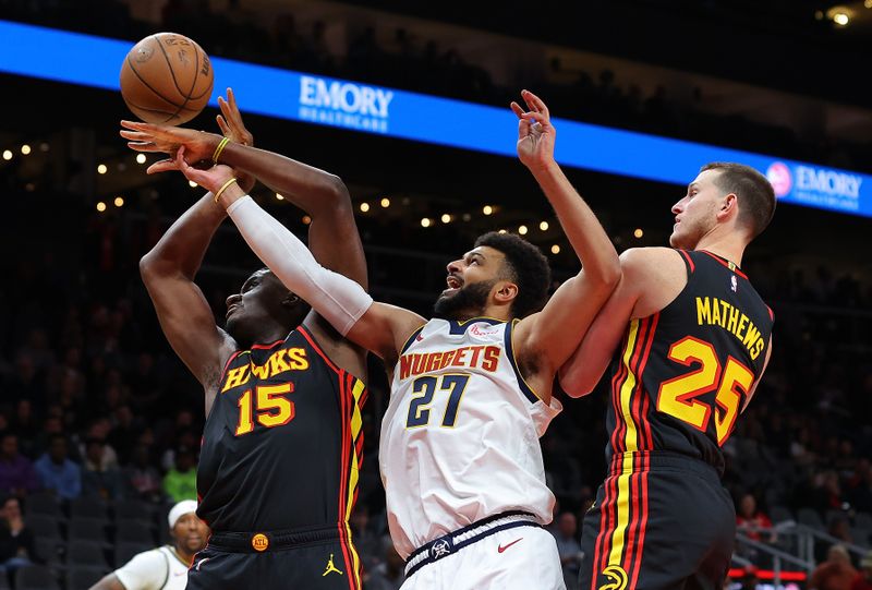 ATLANTA, GEORGIA - DECEMBER 11:  Jamal Murray #27 of the Denver Nuggets battles for a rebound against Clint Capela #15 and Garrison Mathews #25 of the Atlanta Hawks during the first quarter at State Farm Arena on December 11, 2023 in Atlanta, Georgia.  NOTE TO USER: User expressly acknowledges and agrees that, by downloading and/or using this photograph, user is consenting to the terms and conditions of the Getty Images License Agreement.  (Photo by Kevin C. Cox/Getty Images)