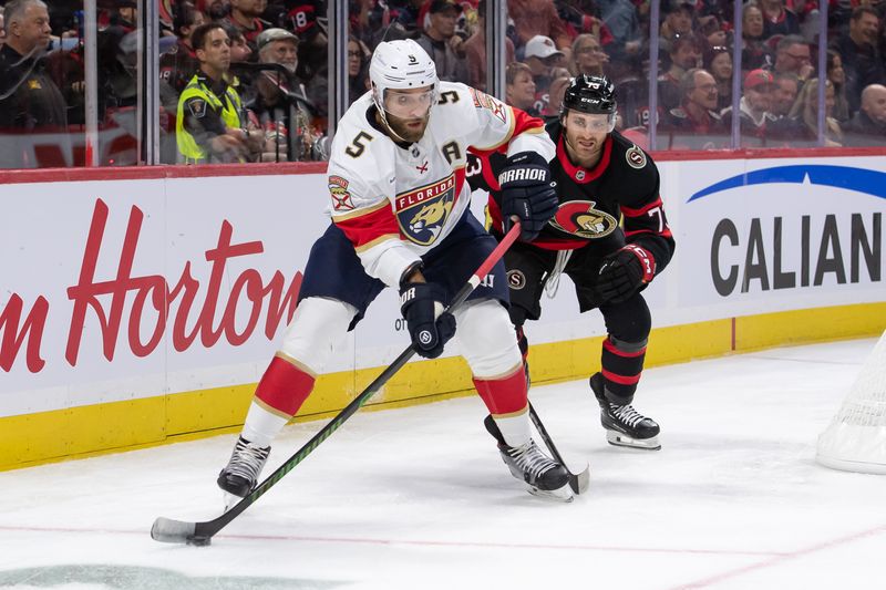 Oct 10, 2024; Ottawa, Ontario, CAN; Florida Panthers defenseman Aaron Ekblad (5) skates with the puck in front of Ottawa Senators left wing Noah Gregor (73) in the first period at the Canadian Tire Centre. Mandatory Credit: Marc DesRosiers-Imagn Images