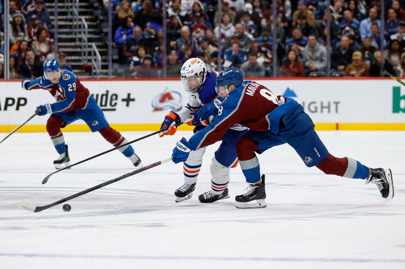 Jan 16, 2025; Denver, Colorado, USA; Edmonton Oilers left wing Zach Hyman (18) and Colorado Avalanche defenseman Cale Makar (8) battle for the puck in the first period at Ball Arena. Mandatory Credit: Isaiah J. Downing-Imagn Images