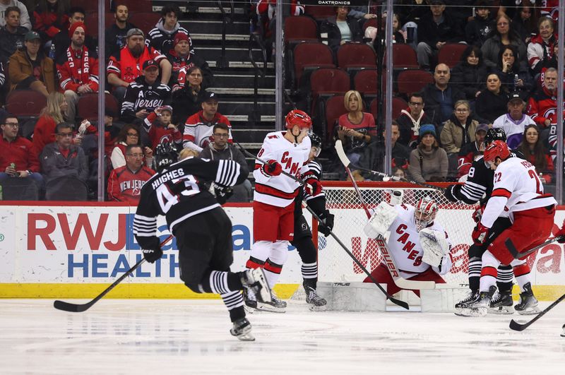 Mar 9, 2024; Newark, New Jersey, USA; New Jersey Devils defenseman Luke Hughes (43) hits the crossbar with a shot against the Carolina Hurricanes during the first period at Prudential Center. Mandatory Credit: Ed Mulholland-USA TODAY Sports