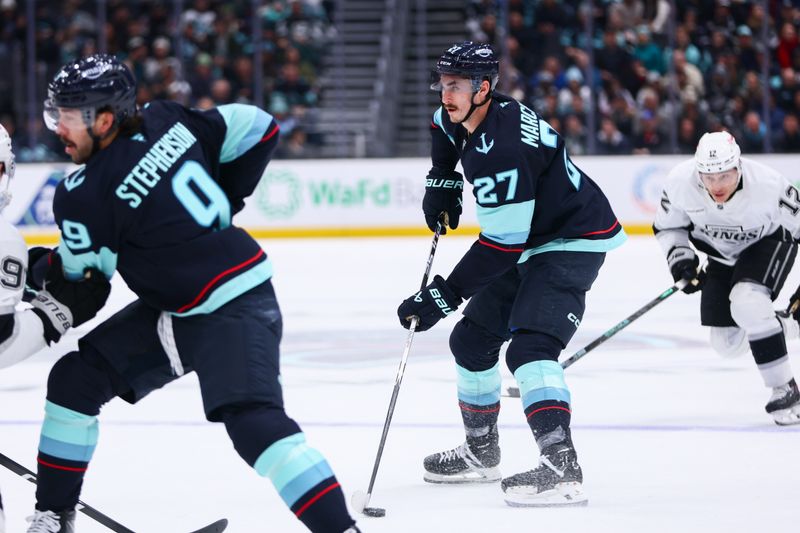 Dec 10, 2025; Seattle, Washington, USA;  Seattle Kraken left wing Mason Marchment (27) looks to shoot while defended by Los Angeles Kings defenseman Joel Edmundson (6) in the first period at Climate Pledge Arena. Mandatory Credit: Kevin Ng-Imagn Images