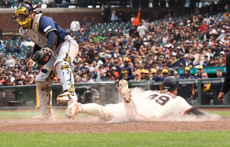 Apr 24, 2025; San Francisco, California, USA; San Francisco Giants second baseman Tyler Fitzgerald (49) scores a run below Milwaukee Brewers catcher Eric Haase (13) during the eighth inning at Oracle Park. Mandatory Credit: Kelley L Cox-Imagn Images