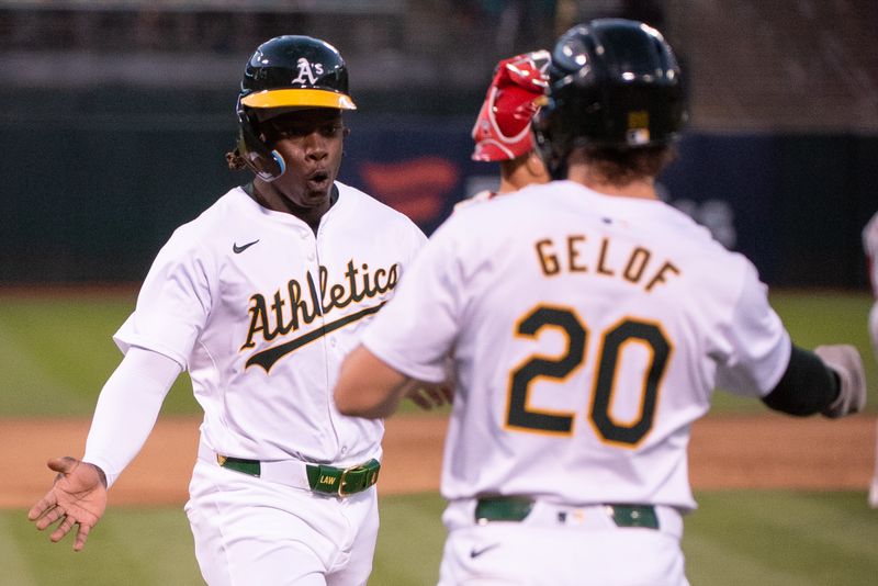 Jul 2, 2024; Oakland, California, USA; Oakland Athletics outfielder Lawrence Butler (4) celebrates with second base Zack Gelof (20) after scoring against the Los Angeles Angels during the sixth inning at Oakland-Alameda County Coliseum. Mandatory Credit: Ed Szczepanski-USA TODAY Sports