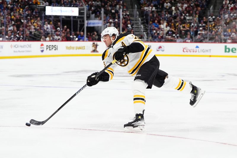 Oct 16, 2024; Denver, Colorado, USA; Boston Bruins defenseman Charlie McAvoy (73) shoots the puck in the third period against the Colorado Avalanche at Ball Arena. Mandatory Credit: Ron Chenoy-Imagn Images