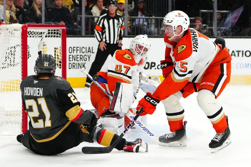 Oct 13, 2024; Las Vegas, Nevada, USA; Anaheim Ducks defenseman Urho Vaakanainen (5) checks Vegas Golden Knights center Brett Howden (21) as Ducks goaltender James Reimer (47) defends the goal during the first period at T-Mobile Arena. Mandatory Credit: Stephen R. Sylvanie-Imagn Images