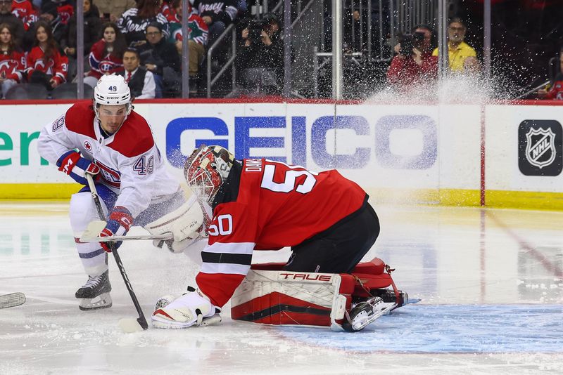 Jan 17, 2024; Newark, New Jersey, USA; New Jersey Devils goaltender Nico Daws (50) makes a save on Montreal Canadiens left wing Rafael Harvey-Pinard (49) during the third period at Prudential Center. Mandatory Credit: Ed Mulholland-USA TODAY Sports