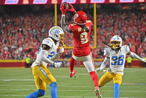 Kansas City Chiefs wide receiver DeAndre Hopkins (8) goes up for the ball against Los Angeles Chargers cornerback Cam Hart (20) and cornerback Ja'Sir Taylor (36) during an NFL football game Sunday, Dec. 8, 2024, in Kansas City, Mo. (AP Photo/Peter Aiken)