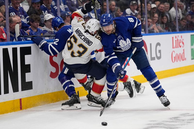 May 5, 2025; Toronto, Ontario, CAN; Florida Panthers forward Brad Marchand (63) is knocked over by Toronto Maple Leafs defenseman Chris Tanev (8) during the second period of the second round of the 2025 Stanley Cup Playoffs at Scotiabank Arena. Mandatory Credit: John E. Sokolowski-Imagn Images