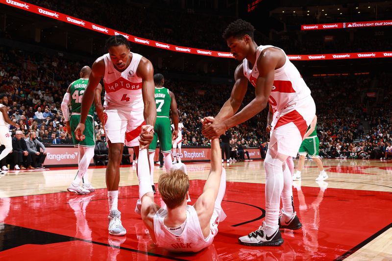 TORONTO, CANADA - OCTOBER 15: Scottie Barnes #4 and Ochai Agbaji #30 help up Gradey Dick #1 of the Toronto Raptors against the Boston Celtics on October 15, 2024 at the Scotiabank Arena in Toronto, Ontario, Canada.  NOTE TO USER: User expressly acknowledges and agrees that, by downloading and or using this Photograph, user is consenting to the terms and conditions of the Getty Images License Agreement.  Mandatory Copyright Notice: Copyright 2024 NBAE (Photo by Vaughn Ridley/NBAE via Getty Images)