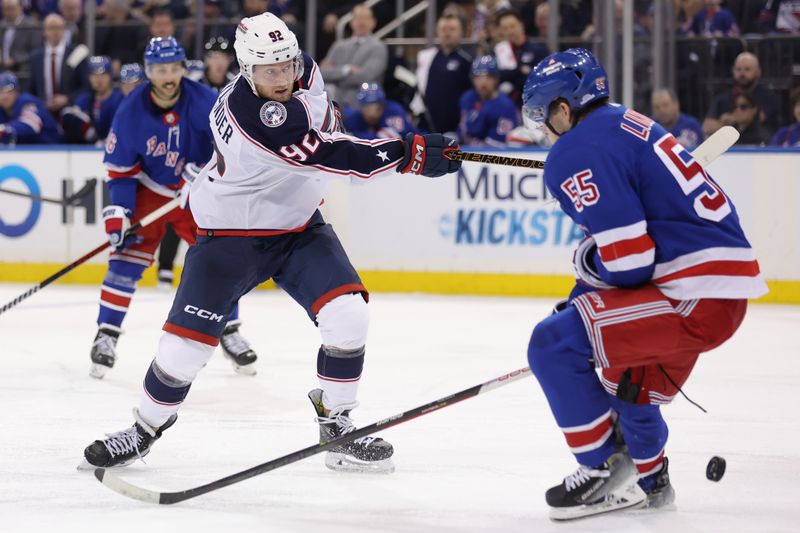 Feb 28, 2024; New York, New York, USA; Columbus Blue Jackets left wing Alexander Nylander (92) shoots the puck against New York Rangers defenseman Ryan Lindgren (55) during the third period at Madison Square Garden. Mandatory Credit: Brad Penner-USA TODAY Sports