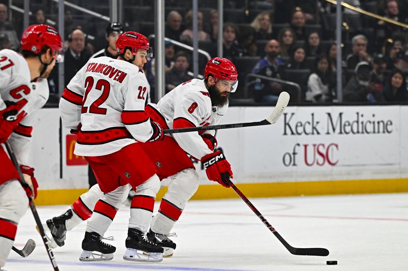 Mar 22, 2025; Los Angeles, California, USA; Carolina Hurricanes defenseman Brent Burns (8) moves the puck with center Logan Stankoven (22) against the Los Angeles Kings during the first period at Crypto.com Arena. Mandatory Credit: Jonathan Hui-Imagn Images
