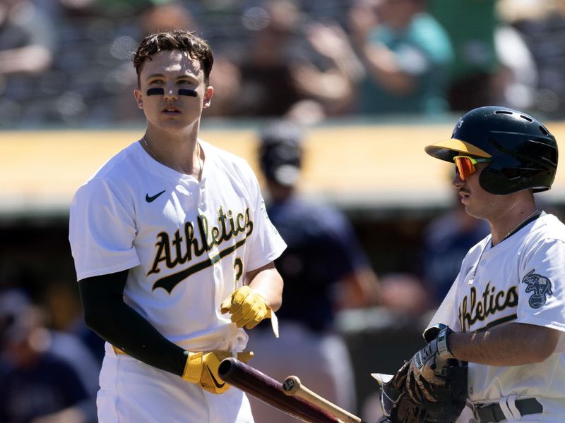 Sep 5, 2024; Oakland, California, USA; Oakland Athletics second baseman Zack Gelof (20) hands off his equipment to the batboy after striking out against the Seattle Mariners during the third inning at Oakland-Alameda County Coliseum. Mandatory Credit: D. Ross Cameron-Imagn Images