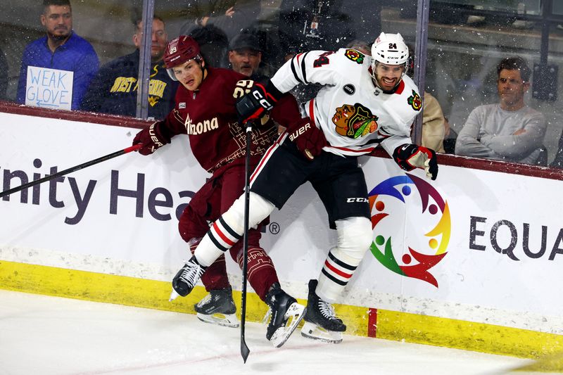 Mar 5, 2024; Tempe, Arizona, USA;  Chicago Blackhawks defenseman Jaycob Megna (24) checks Arizona Coyotes center Barrett Hayton (29) during the first period at Mullett Arena. Mandatory Credit: Mark J. Rebilas-USA TODAY Sports