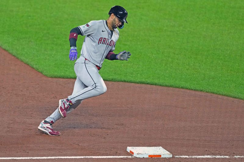 May 10, 2024; Baltimore, Maryland, USA; Arizona Diamondbacks outfielder Lourdes Gurriel Jr. (12) rounds third base to score a run in the seventh inning against the Baltimore Orioles at Oriole Park at Camden Yards. Mandatory Credit: Mitch Stringer-USA TODAY Sports