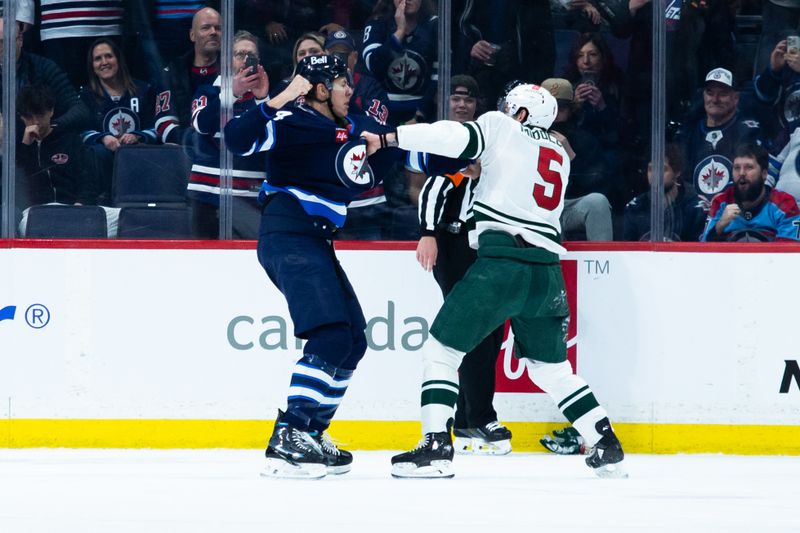 Feb 20, 2024; Winnipeg, Manitoba, CAN; Winnipeg Jets defenseman Logan Stanley (64) fights Minnesota Wild defenseman Jake Middleton (5) during first period at Canada Life Centre. Mandatory Credit: Terrence Lee-USA TODAY Sports