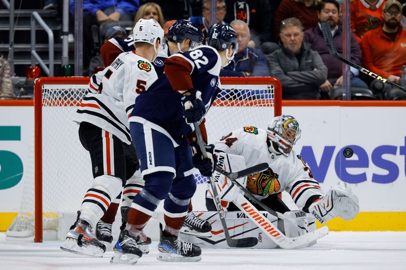Oct 28, 2024; Denver, Colorado, USA; Chicago Blackhawks goaltender Petr Mrazek (34) deflects a shot as defenseman Connor Murphy (5) and Colorado Avalanche center Ivan Ivan (82) and right wing Nikolai Kovalenko (51) in the third period at Ball Arena. Mandatory Credit: Isaiah J. Downing-Imagn Images
