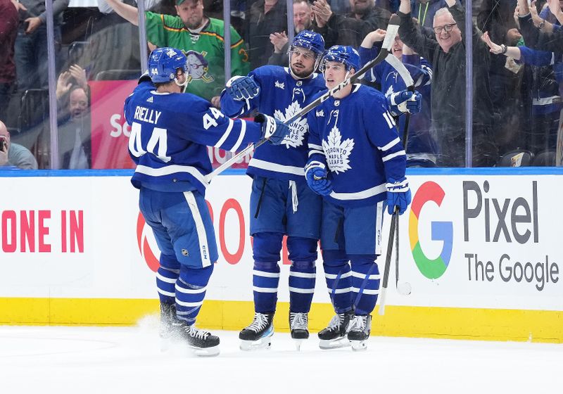 Mar 6, 2024; Toronto, Ontario, CAN; Toronto Maple Leafs center Auston Matthews (34) scores the winning goal and celebrates with Toronto Maple Leafs right wing Mitchell Marner (16) and defenseman Morgan Rielly (44) against the Buffalo Sabres during the overtime period at Scotiabank Arena. Mandatory Credit: Nick Turchiaro-USA TODAY Sports