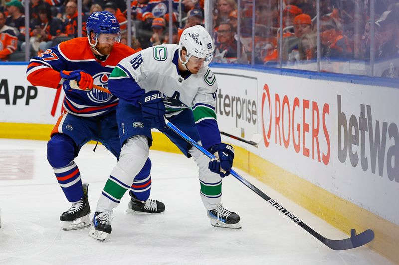 May 18, 2024; Edmonton, Alberta, CAN; Vancouver Canucks forward Nils Aman (88) protects the puck from Edmonton Oilers defensemen Brett Kulak (27) during the second period in game six of the second round of the 2024 Stanley Cup Playoffs at Rogers Place. Mandatory Credit: Perry Nelson-USA TODAY Sports