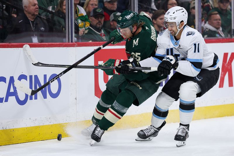 Mar 10, 2026; Saint Paul, Minnesota, USA; Minnesota Wild defenseman Jonas Brodin (25) and Utah Mammoth right wing Dylan Guenther (11) compete for the puck during the first period at Grand Casino Arena. Mandatory Credit: Matt Krohn-Imagn Images