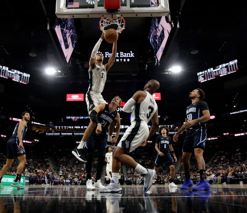 SAN ANTONIO, TX - OCTOBER 09:  Victor Wembanyama #1 of the San Antonio Spurs dunks against Moritz Wagner #21 of the Orlando Magic in the first half of a preseason game at Frost Bank Center on October 9, 2024 in San Antonio, Texas. NOTE TO USER: User expressly acknowledges and agrees that, by downloading and or using this photograph, User is consenting to terms and conditions of the Getty Images License Agreement. (Photo by Ronald Cortes/Getty Images)