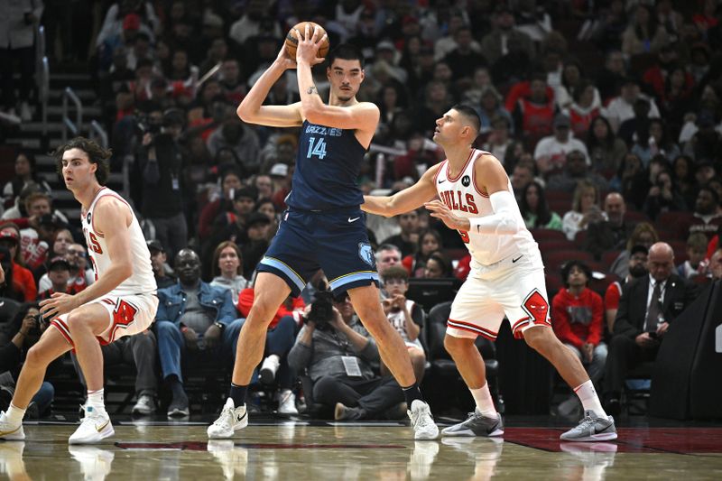 CHICAGO, ILLINOIS - OCTOBER 12: Zach Edey #14 of the Memphis Grizzlies posts up against Nikola Vucevic #9 of the Chicago Bulls in the first half of a preseason game at the United Center on October 12, 2024 in Chicago, Illinois. NOTE TO USER: User expressly acknowledges and agrees that, by downloading and or using this photograph, User is consenting to the terms and conditions of the Getty Images License Agreement. (Photo by Quinn Harris/Getty Images)